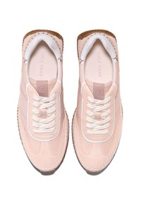 Ljusrosa sneakers med mocka- och lädertextur, utrustade med vita snören, vadderat innertyg och gummisula med räfflad detalj.