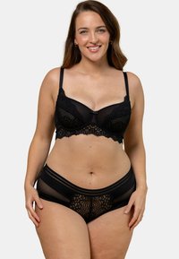 Soutien-gorge en dentelle noire avec un bord festonné et des panneaux en mesh, comportant des bretelles ajustables et des motifs floraux. Culotte assortie en dentelle noire incluse.