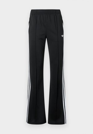 Svarta träningsbyxor med resår i midjan, sidofickor och vita vertikala ränder längs sidorna. Har en liten logotyp på framsidan.