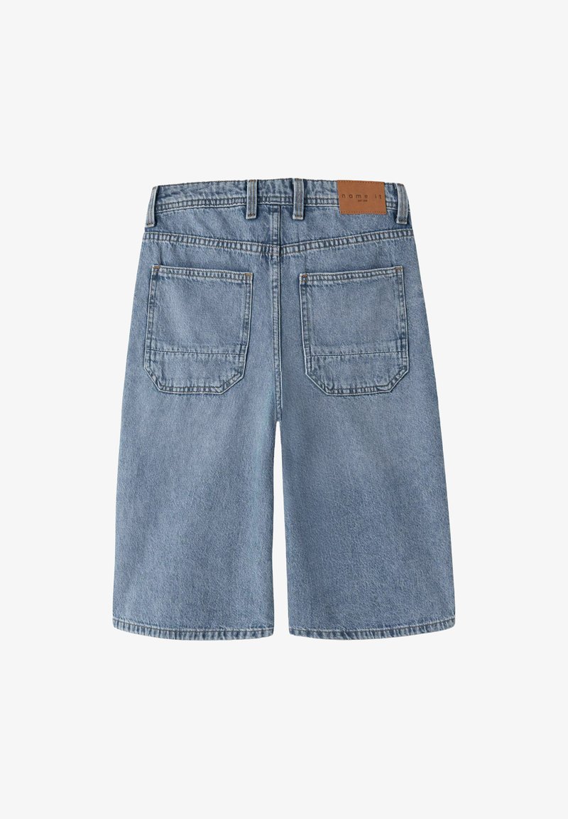 Svetlomodré rifľové šortky dĺžky ku kolenám s pútkami na opasok, dvoma vonkajšími zadnými vreckami a malou hnedou značkou na páse.