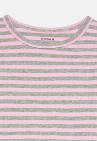 Stripete kortermet topp laget av ribbet stoff, med vekselsvis grå og lys rosa striper og rund hals. Merkeetikett synlig.