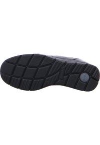 Schwarze Gummisohle mit einem strukturierten Grip-Muster, tiefen Rillen und einem runden Logodetail. Flache und leicht erhöhte Kanten.