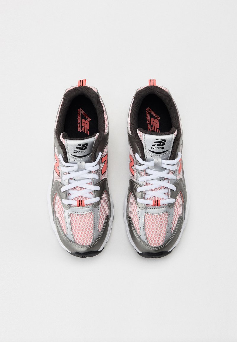 Graue und rosa Sportschuhe mit Mesh-Obermaterial, weißen Schnürsenkeln und strukturierten Sohlen. Merkmale das New Balance-Logo und orangefarbene Akzente.