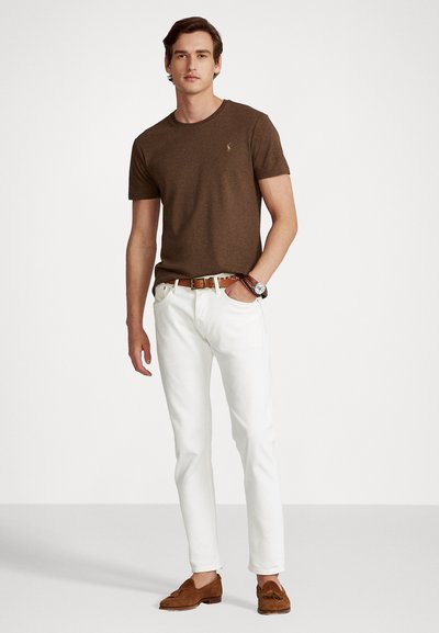 Ruskea lyhythihainen T-paita, valkoiset slim-fit farkut, ruskeat mokkasandaalit, ruskea nahkavyö ja hopeinen pyöreäkasvoinen kello.