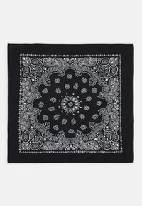 Bandana noire avec des motifs paisley et floraux blancs complexes, comportant un motif central et bordée de motifs décoratifs. Texture de tissu douce.