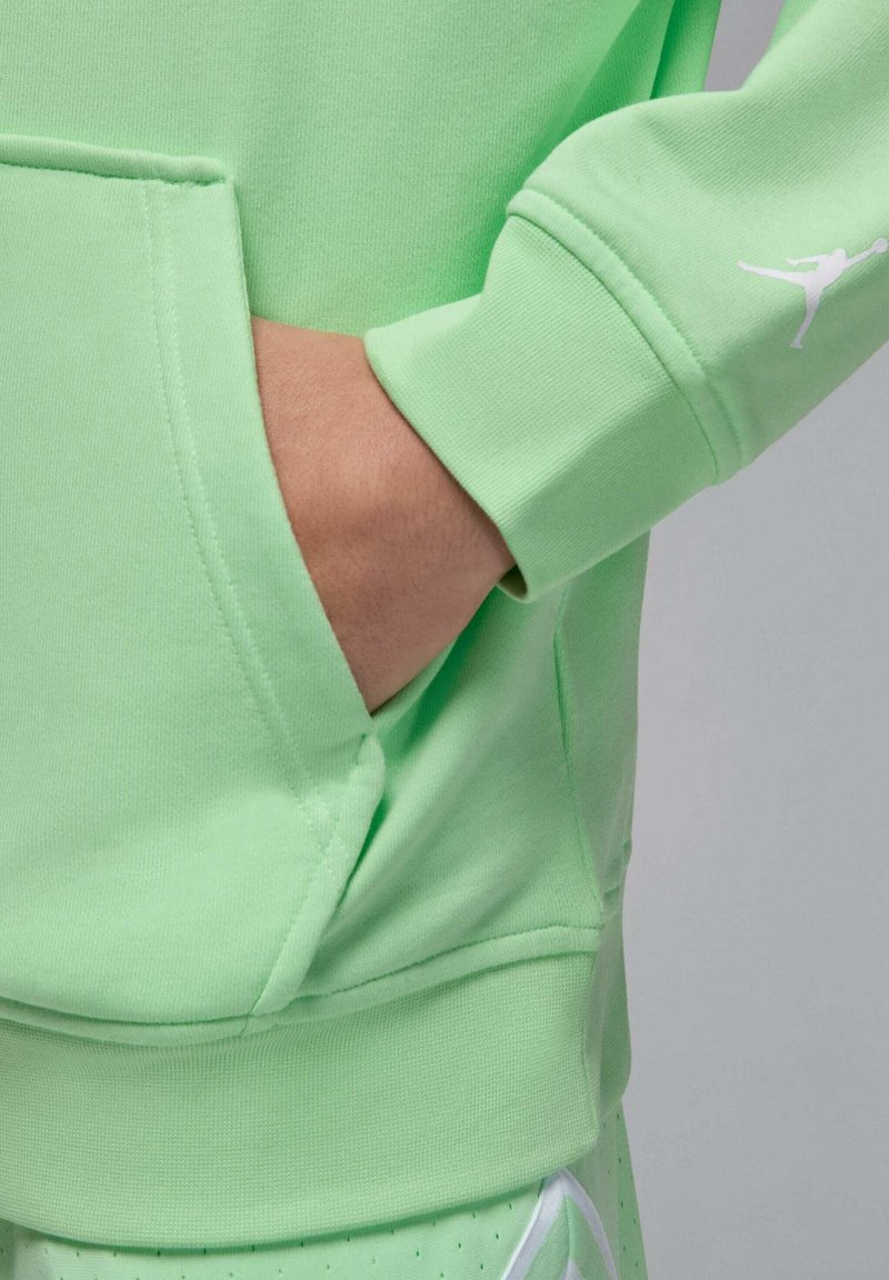 Grüner Sweatshirt aus weichem Stoff mit einer Kängurutasche, gerippten Bündchen und einem kleinen weißen Logo-Detail am Ärmel.