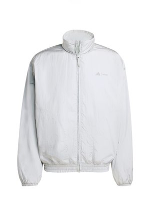 Giacca leggera bianca con colletto alto, chiusura frontale con zip e polsini elasticizzati. Presenta una texture sottile e un logo sulla parte sinistra del petto.