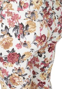 Pantaloni floreali con sfondo bianco e grandi fiori colorati in tonalità di rosa, marrone bordeaux e beige; includono un dettaglio della tasca posteriore.