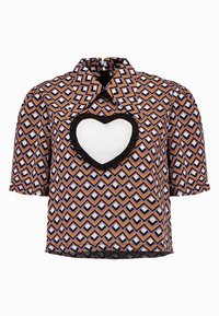 Blusa a maniche corte in tessuto a fantasia con un design geometrico in viola, arancione e nero, con una toppa bianca a forma di cuore.