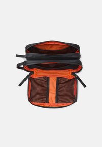 Borsa nera con zip e interno arancione. Due scomparti e tasche in rete per l'organizzazione. Texture liscia con bordi resistenti.