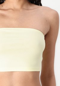 Yellow strapless top made from a smooth, stretchy fabric; features a simple design with clean edges and no embellishments.