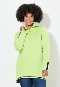 Pullover verde chiaro con colletto a zip parziale, texture a costine e dettagli in blu navy sulle maniche e sull'orlo. Presenta un ampio scollo.