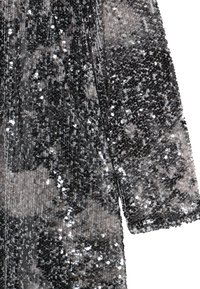 Tessuto in sequins neri e argentati, caratterizzato da una texture scintillante. Il materiale è morbido con una superficie leggermente irregolare a causa dei sequins sparsi.