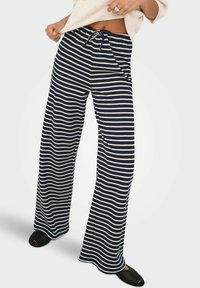 Szerokie spodnie w kolorze granatowym z białymi poziomymi paskami, z regulowanym paskiem w talii i miękkim, teksturowanym materiałem.