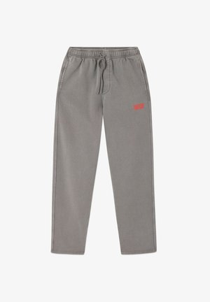 Pelēkas sporta bikses ar elastīgu vidukli un regulējamu auklu. Aprīkotas ar sānu kabatām un mazu sarkanu logotipu uz augšējās kreisās kājas.