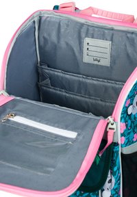 Uvnitř tašky s šedým plátnem, růžovými zipy, několika kapsami a průhlednou kapsou se zipem pro úložný prostor.