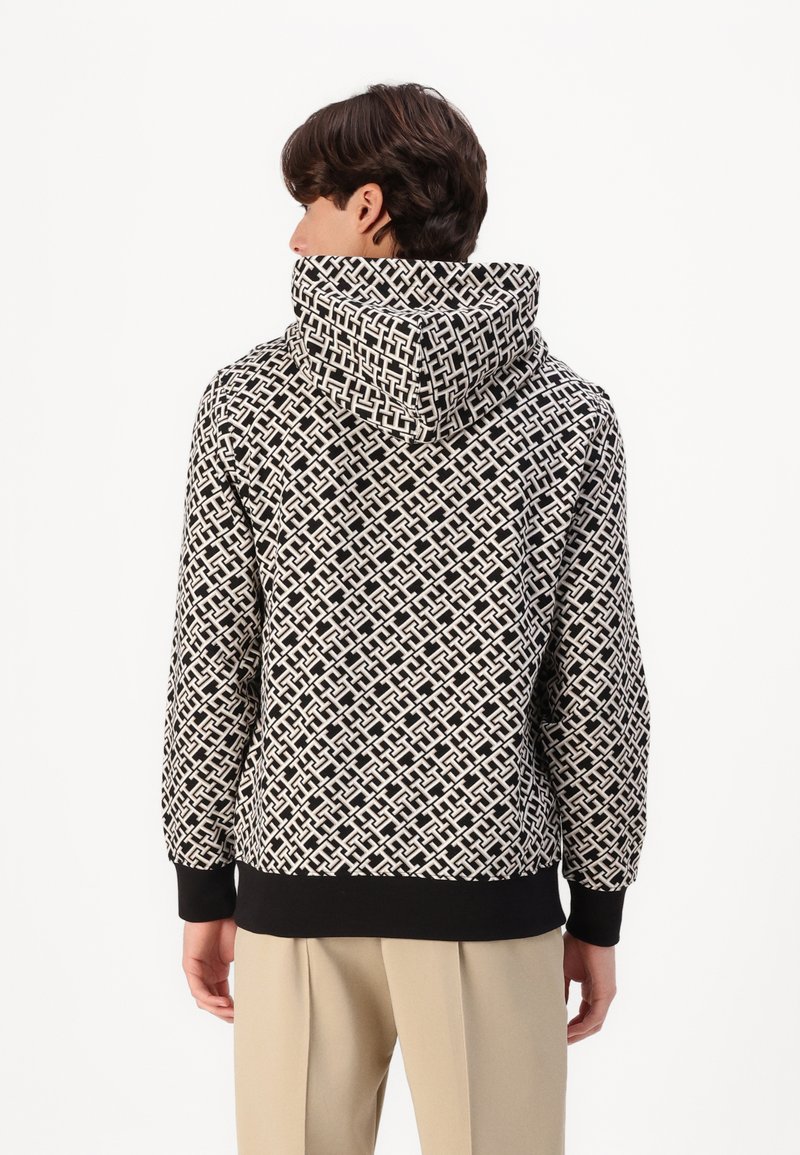 Hoodie a stampa bianca e nera con un design geometrico testurizzato, dotato di cappuccio con cordino e polsini e orlo a coste neri.