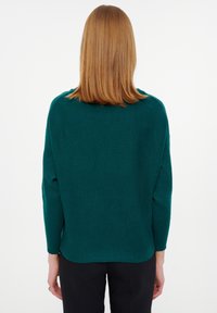 Groene geribbelde trui met een ronde halslijn en lange mouwen, met een relaxte pasvorm en een rechte zoom aan de achterkant.