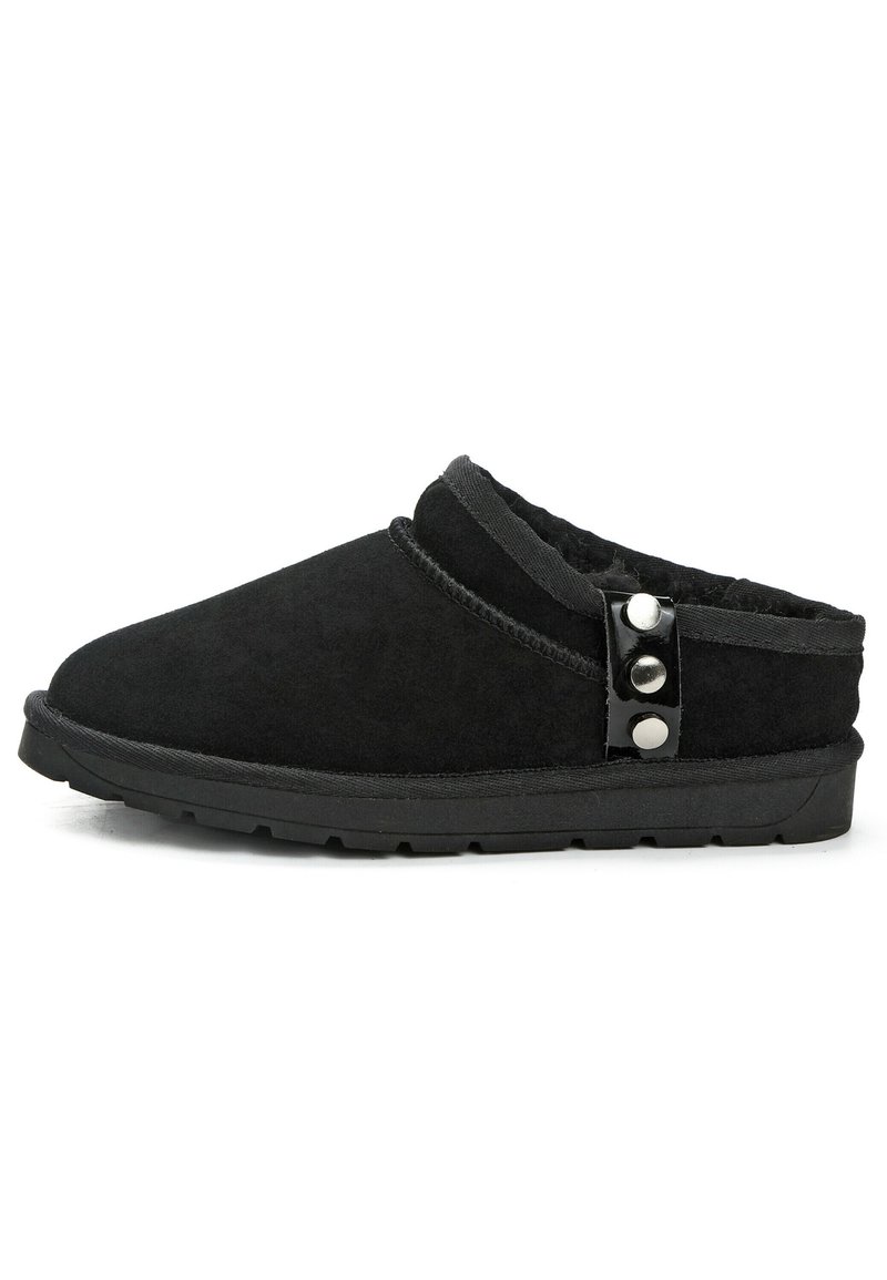 Schwarze Wildlederschuhe mit einem weichen Innenfutter, abgerundeter Spitze, gesticktem Detail und zwei dekorativen schwarzen Knöpfen an der Seite.
