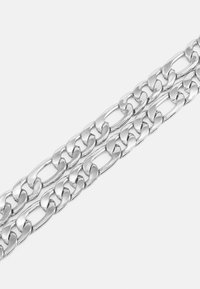 Deux chaînes parallèles en argent poli avec des maillons ovales et plats entrelacés sur un fond blanc.