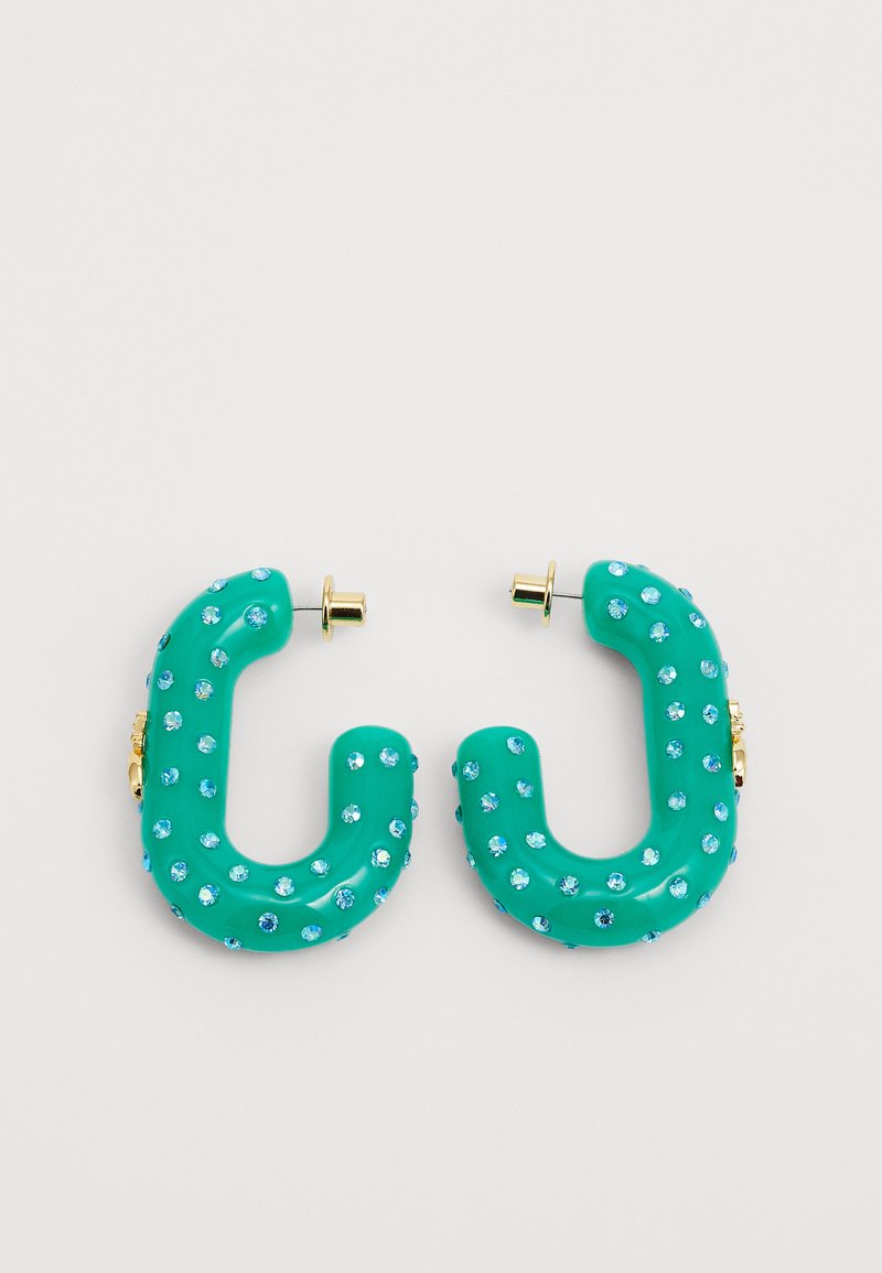 Brincos de resina teal em forma da letra "C", adornados com strass azul claro e com acabamento em metal dourado na parte de trás.