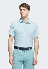 Light blue short-sleeve polo shirt with a subtle white floral pattern, collared neckline, and button detail, paired with light blue trousers and a black belt.