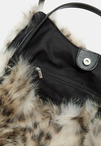 Borsa a spalla nera in tessuto con bordo in finta pelliccia marrone maculata, dotata di una tasca con zip e manico sintetico nero con finiture in metallo.