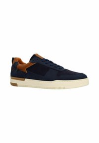 Marineblauwe sneaker met bruine accenten, voorzien van veters, een gestructureerde neus en een crème kleurige zool, gepresenteerd op een witte achtergrond.