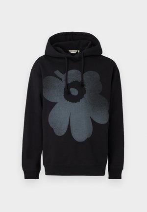 Crna dukserica s velikim sivim cvjetnim grafičkim uzorkom sprijeda, koji ima okrugli središnji dio i zaobljene oblike latica. Dukserica ima kapuljaču s podešavanjem.