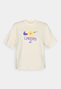 Grietos spalvos medvilnės marškinėliai su purpuriniu Nike logotipu ir geltona gėlių grafika, po kuria didelėmis purpurinėmis raidėmis užrašyta "LAKERS". Trumpomis Rankovėmis, laisvas kirpimas.