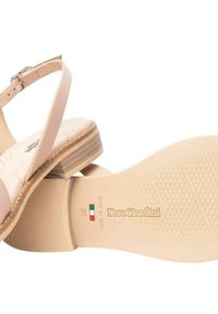 Sandali in pelle beige con tomaia testurizzata, fibbia regolabile e un modesto tacco a blocco con suola sagomata etichettata "NeroGiardini."