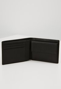 Cartera de cuero negro con un acabado texturizado, que cuenta con múltiples ranuras para tarjetas y un compartimento, abierta para mostrar su diseño interior.