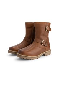 Een paar bruin leren boots tot halverwege de kuit met een gestructureerd oppervlak, robuuste zolen en verstelbare metalen gespen op een witte achtergrond.