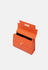 Pochette en cuir synthétique orange avec un design structuré, une quincaillerie dorée et un intérieur noir contrastant. Dotée d'une fermeture à l'avant.