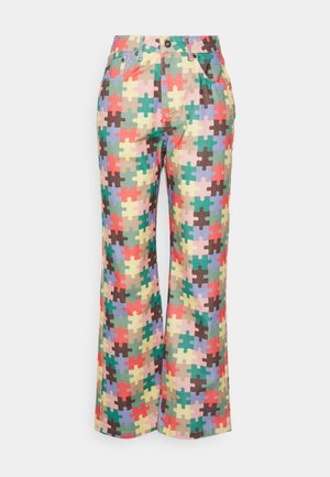 Calças coloridas com um padrão de puzzle em várias cores, feitas de tecido com um design de perna reta e bolsos frontais.