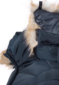 Puffjacka med skalk i marinblått, med avtagbar huva i fuskpäls, ficka med dragkedja och vadderad struktur med en slät finish.