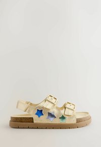 Gyerek arany szandál két állítható csattal és csillag alakú kivágásokkal kék, ezüst és zöld színekben, barna talpon.