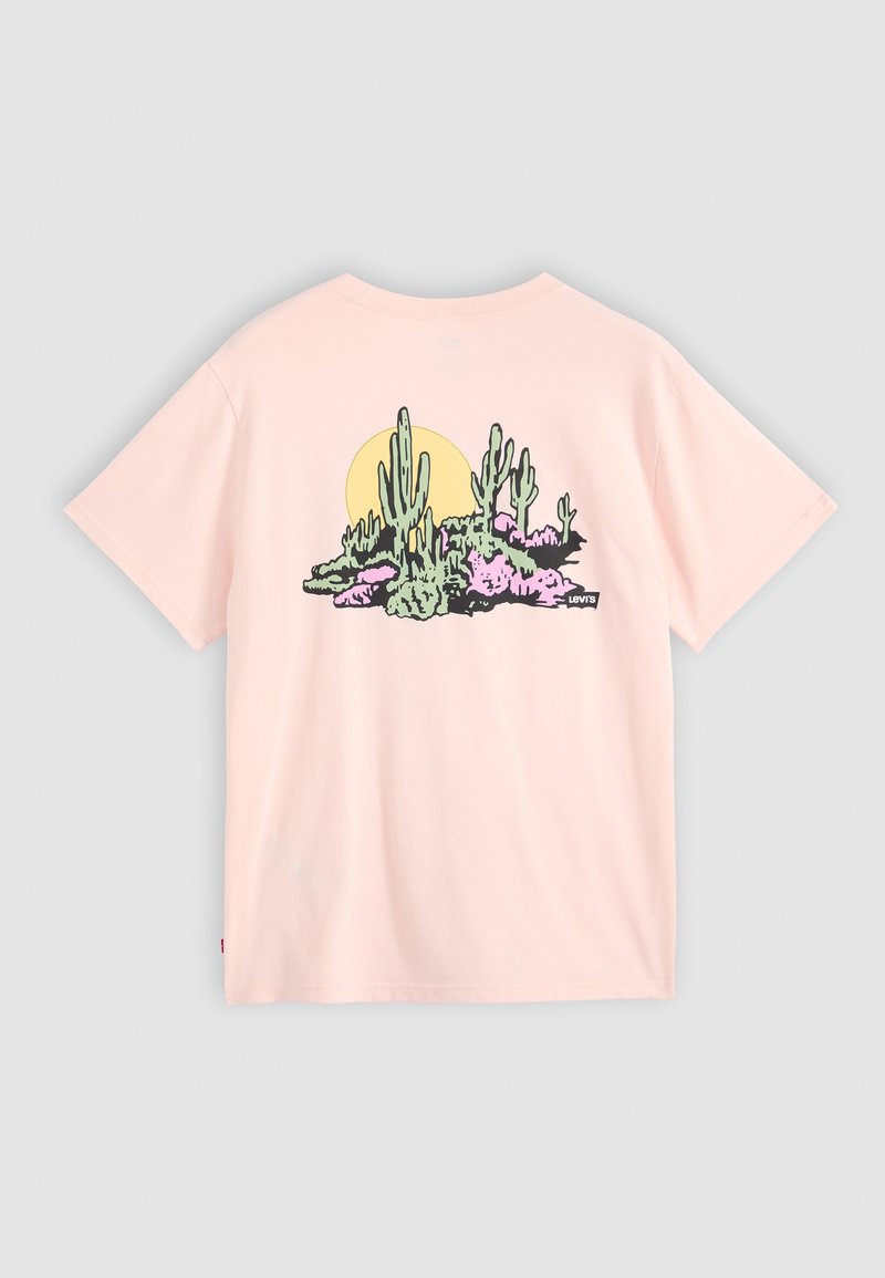 T-shirt in cotone rosa chiaro con una grafica di paesaggio desertico, comprensiva di cactus e sole. Maniche corte, vestibilità rilassata e texture morbida.