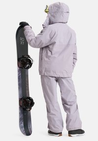 Snowboard met zwarte basis, paarse jas en broek, handschoenen en goggles. Opmerkelijke bindingdetails op de snowboard. Textuur van de buitenstof.