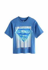 Sininen puuvillapaita lyhyillä hihoilla, jossa on suuri Superman-logo, pystysuorat valkoiset raidat ja tekstit "OLEN SUPERMAN" ja "YLOS JA POIS."