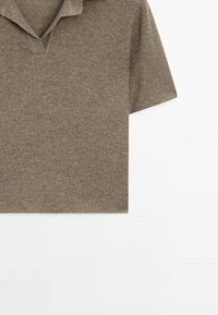 Polo en maille marron à manches courtes avec col et encolure en V sur fond blanc.