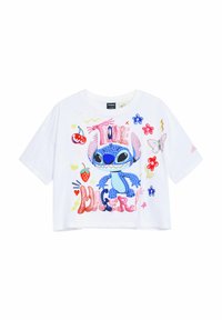 Camiseta blanca recortada con un personaje de dibujos animados azul, diseños florales coloridos y el texto "¡Me encanta el peligro!" en letras brillantes.