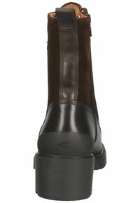 Bottine en daim marron avec accents en cuir, fermeture éclair latérale, bout rond et talon bloc. Présente une semelle extérieure texturée et des détails cousus.