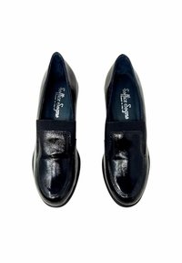 Un paio di mocassini neri lucidi in pelle, con punta arrotondata e fasce elastiche sulla parte frontale, visti dall'alto su uno sfondo bianco.