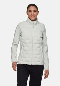 Ljust grå isolerad jacka med hög krage, quiltat mönster, fullständig framtidsdragkedja och elastiska ärmslut, designad för utomhusaktiviteter.