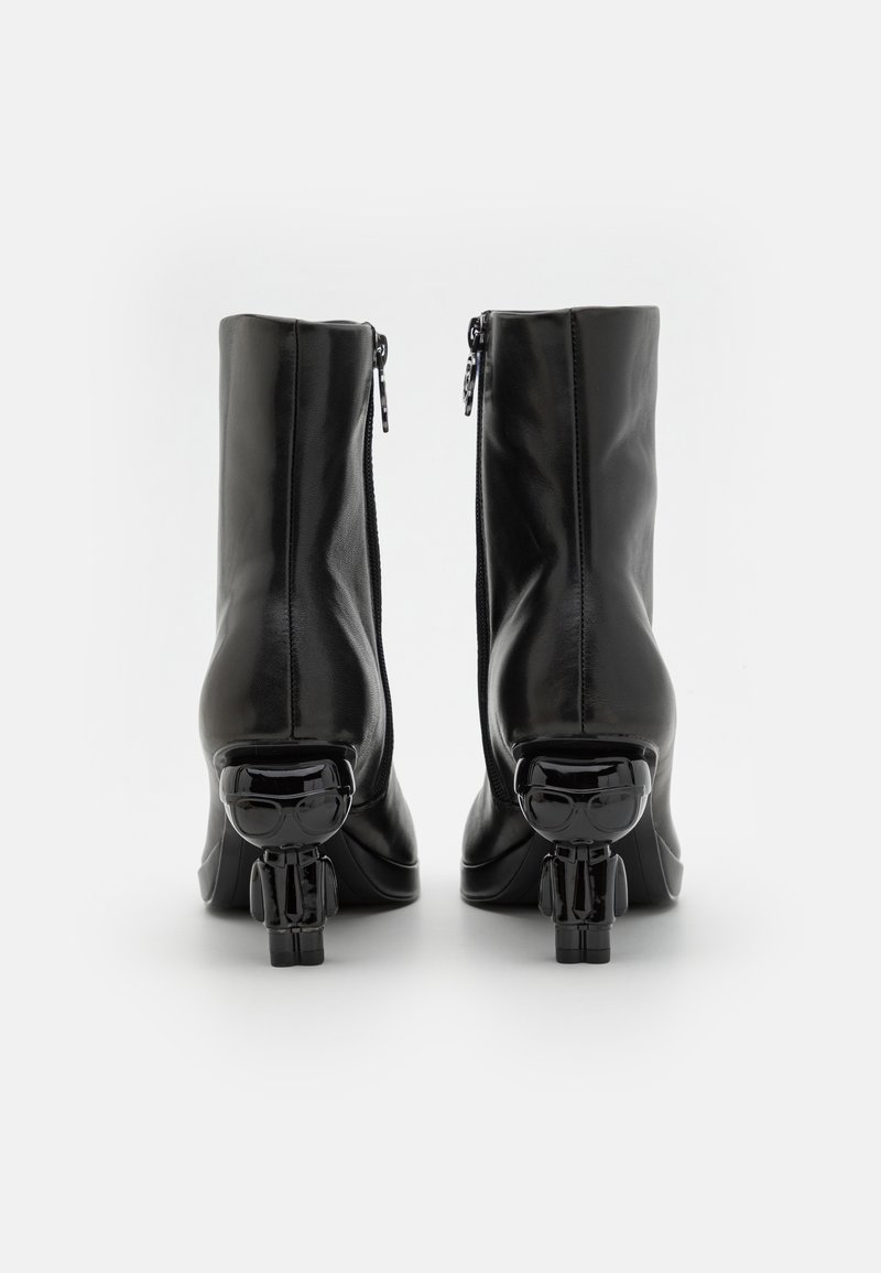 Schwarze Leder-Stiefeletten mit glatter Oberfläche, ausgestattet mit einem Reißverschluss und einzigartigen figürlichen schwarzen Absätzen.