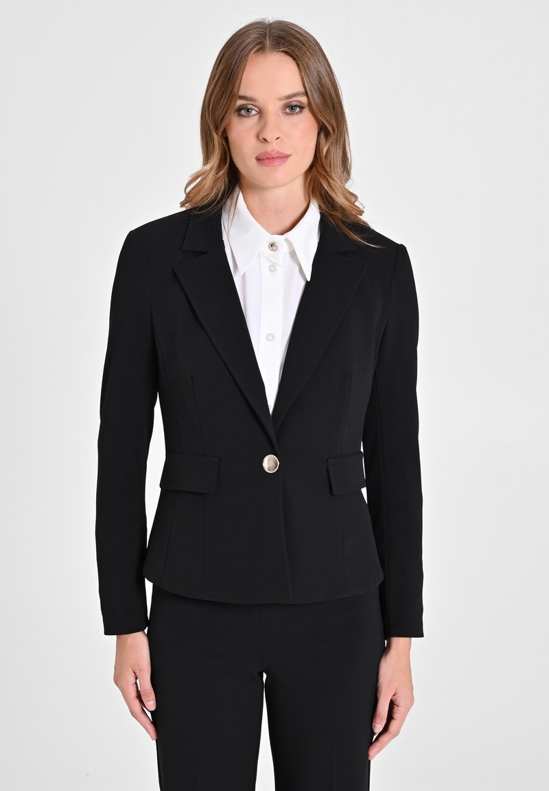 Zwarte op maat gemaakte blazer met een enkele gouden knoopsluiting en twee voorzakken, vervaardigd uit een gladde stof met een lichte glans.