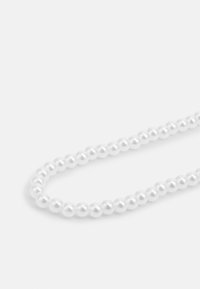 Hvit perlesmykke med jevnt fordelte, sfæriske perler, glatt tekstur og et klassisk design, satt mot en enkel bakgrunn.