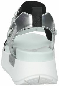 Sandal nero e argento con una suola bianca spessa. Realizzato in materiali sintetici, presenta una struttura con una superficie testurizzata e cinturini regolabili.