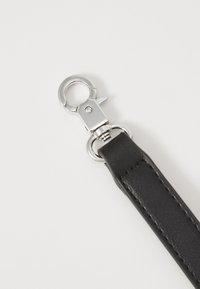 Zwarte leren band met een zilveren metalen sluiting, met een gladde textuur en nette stiksels langs de randen.